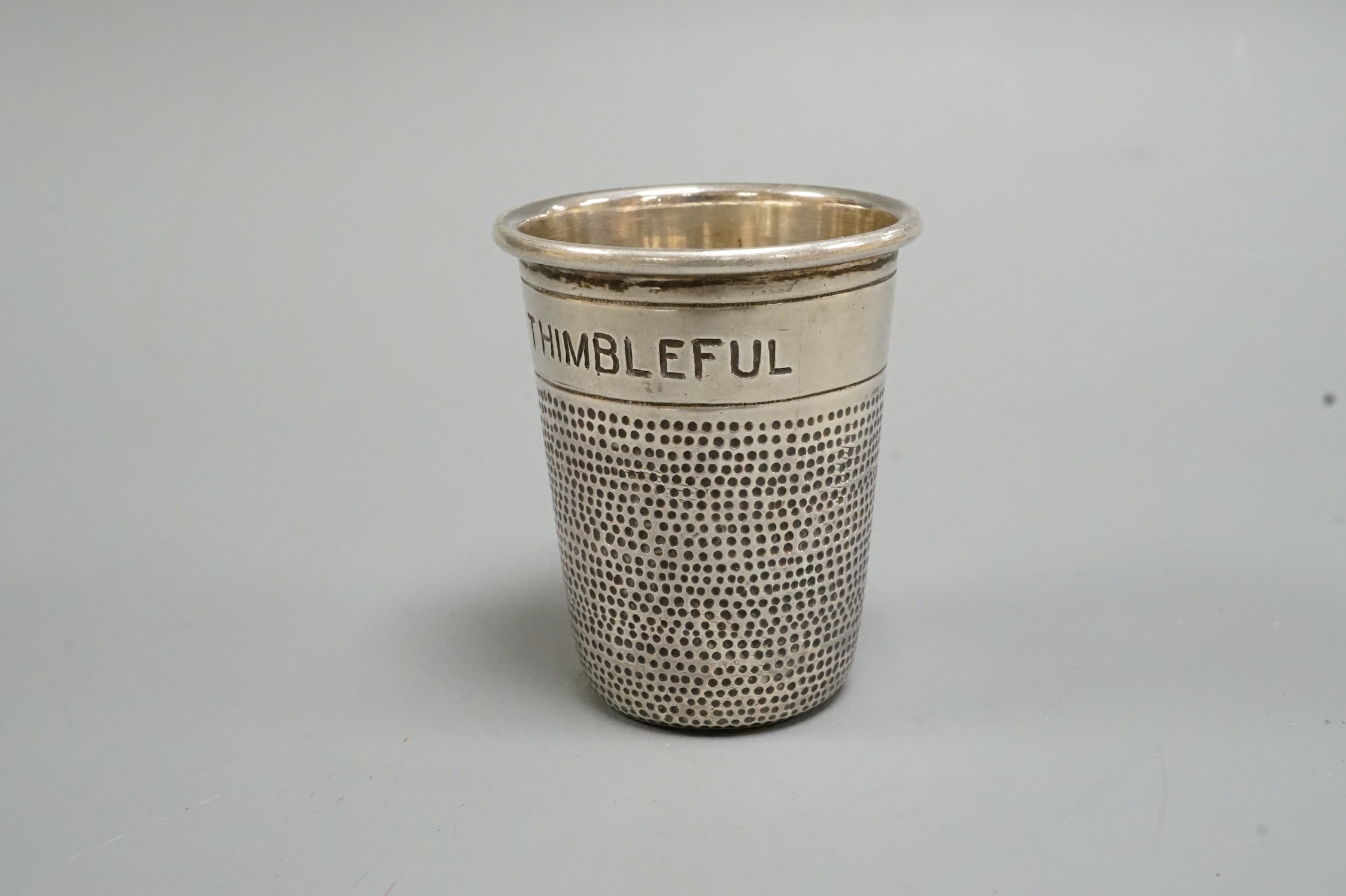 A sterling 'Just a Thimbleful' tot, stamped K.P.D, 51mm.